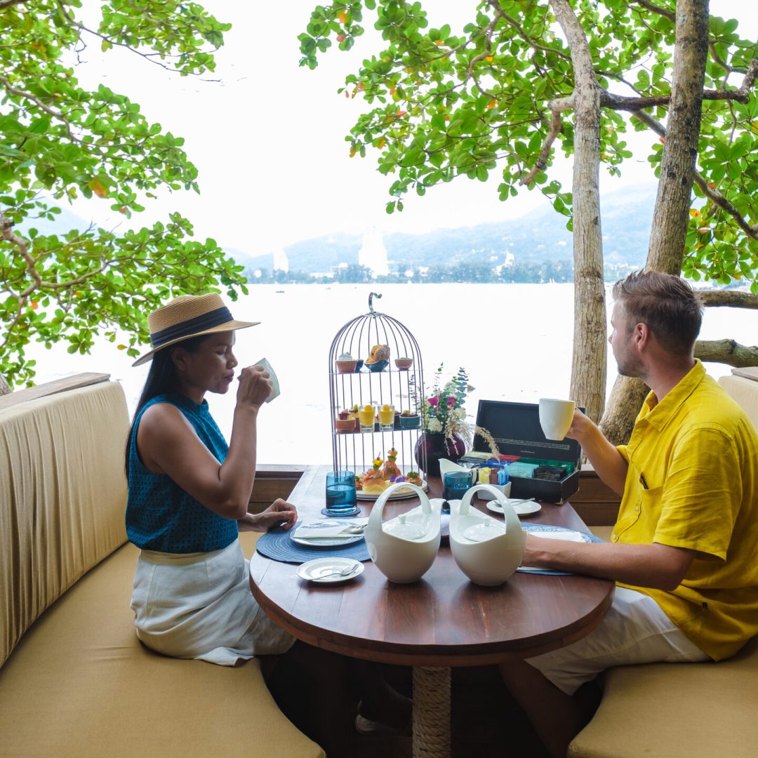 Afternoon tea in a birdnet in the trees of the tropical Island Phuket Thailand, a couple of men and women having afternoon tea in a birdnet basket