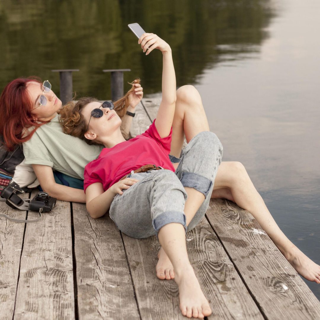 women-laying-dock-taking-selfie
